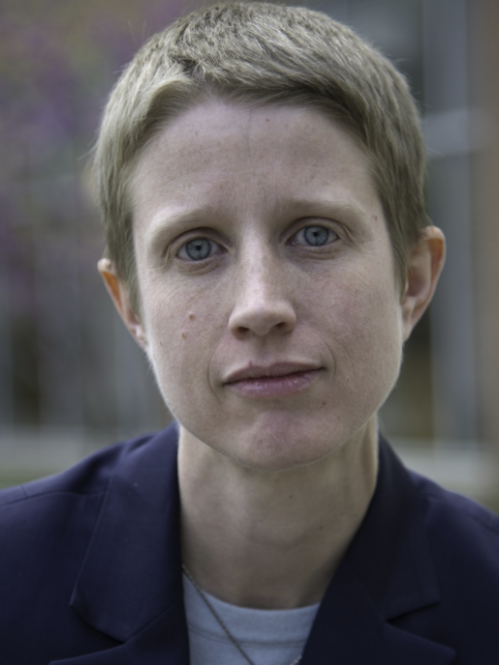 Woman wearing a suit jacket and light colored shirt.