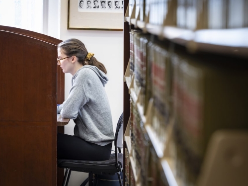 Girl reading near stack of books