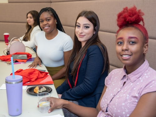 Four new Rutgers student pose for a photo in a classroom during Orientation.