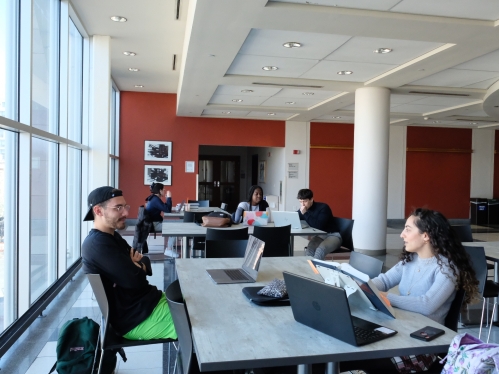 people sitting at tables near large windows