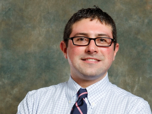 man smiling in shirt, tie and glasses