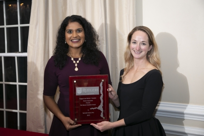 Two women smiling and holding plaque