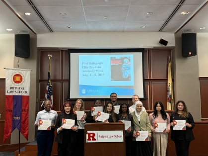 Group of men and women holding up certificates in Rutgers Law School mock courtroom