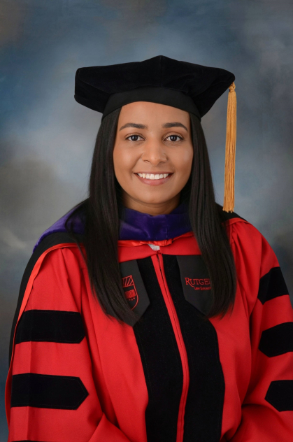 woman smiling and wearing black commencement cap and red and black robe
