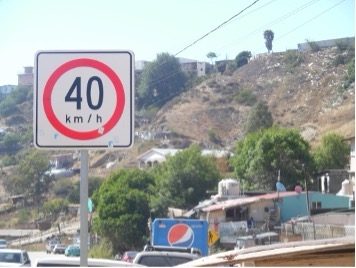 speed sign in media of traffic by hillside