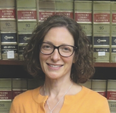 woman smiling in front of book shelf