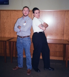 Two people standing back to back with arms folded