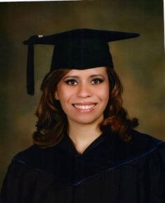 Woman smiling in black graduation cap and gown