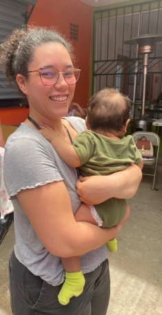 woman with glasses holding baby outdoors