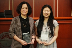 Two women smiling and holding glass plaques