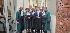 people in robes standing and smiling in hallway