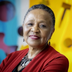 woman smiling in front of colorful art work