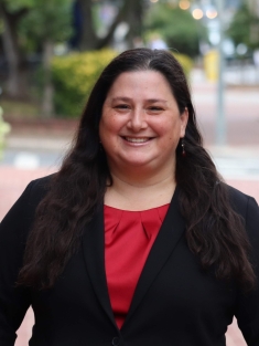 Portrait of woman in black blazer and red blouse
